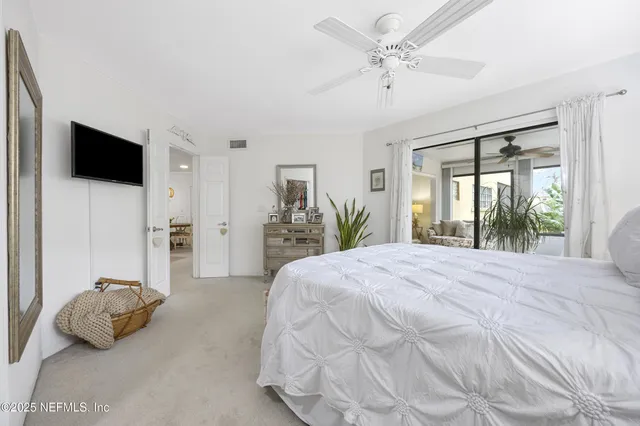 a bedroom with a bed a window and a flat screen television