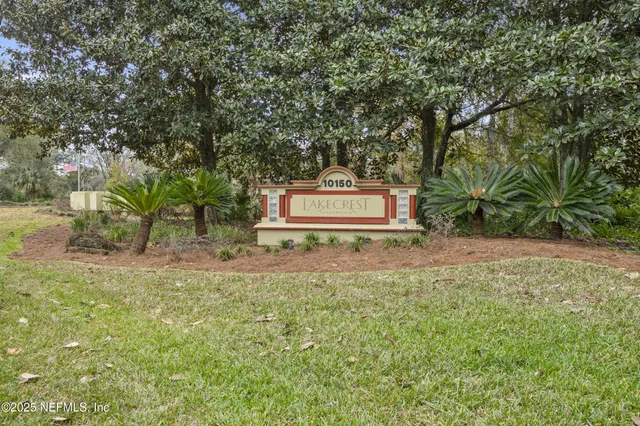 a sign board with tall trees
