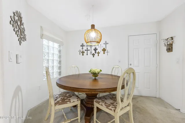 a view of a dining room with furniture and chandelier