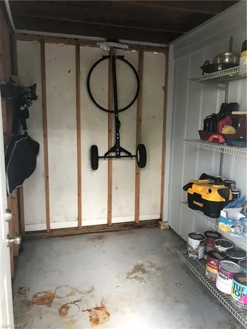 a room with a table chairs and a refrigerator