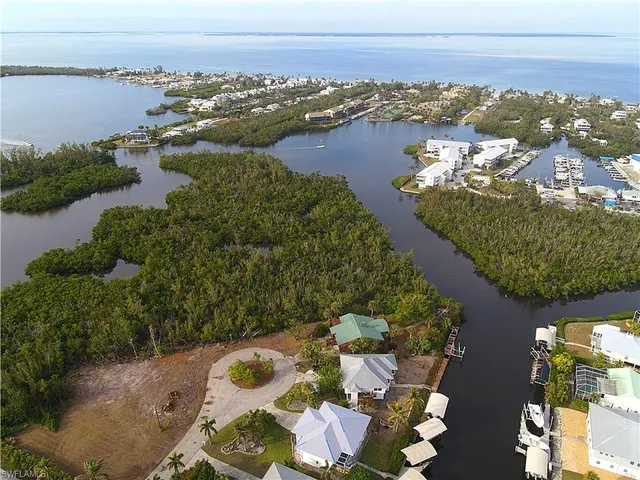 an aerial view of ocean and residential houses with outdoor space