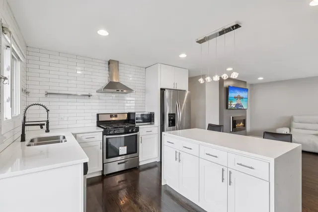 a kitchen with kitchen island stainless steel appliances a sink and a stove