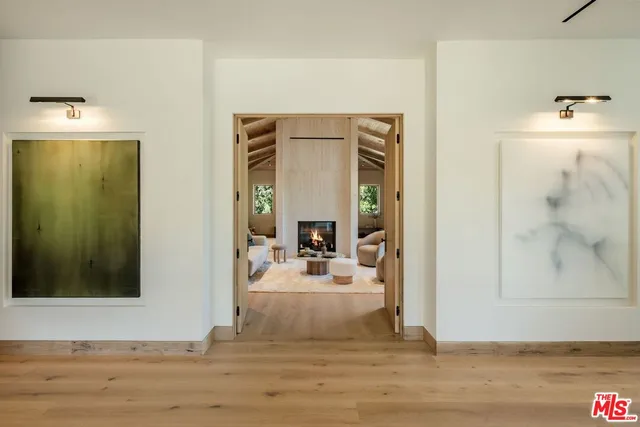 a bed sitting in a spacious bedroom next to a window with a flat screen tv