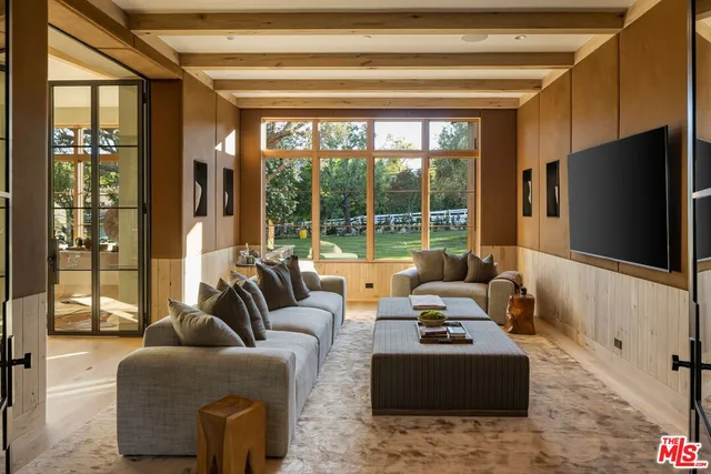 a living room with furniture and a floor to ceiling window