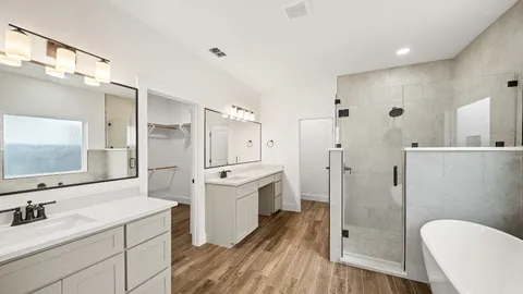 a large bathroom with a sink a toilet a large mirror and shower