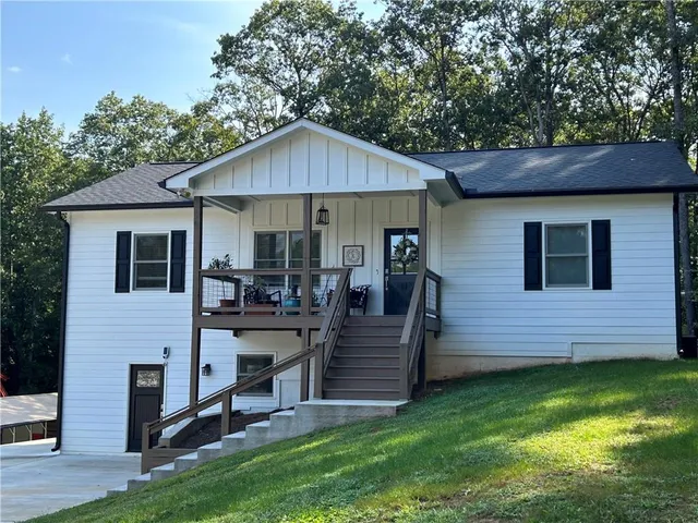 a view of a house with a yard chairs and a table under an umbrella