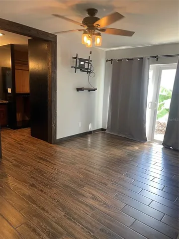 a view of empty room with wooden floor