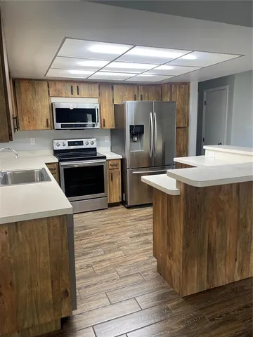 a kitchen with stainless steel appliances kitchen island granite countertop a stove and a sink