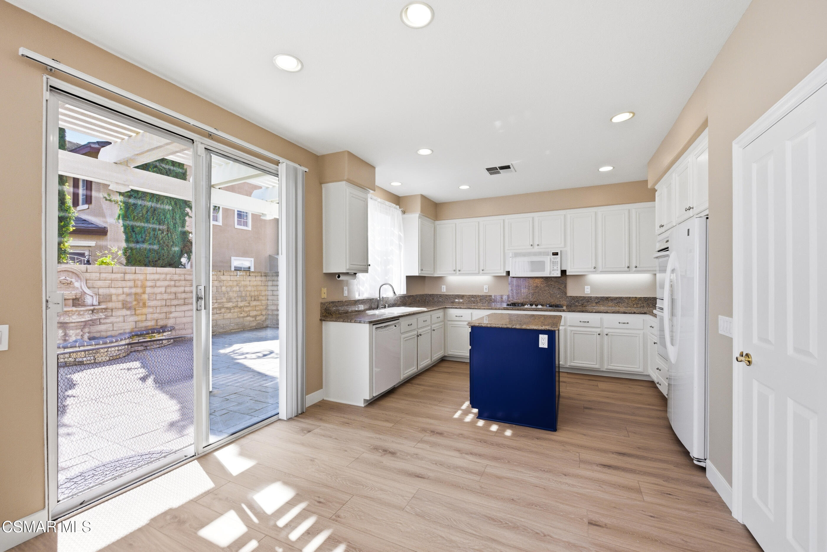 4884 Borders Street Simi Valley, CA 93063 - Photo 12 of 44 a kitchen with stainless steel appliances granite countertop a refrigerator a sink and a stove with wooden floor