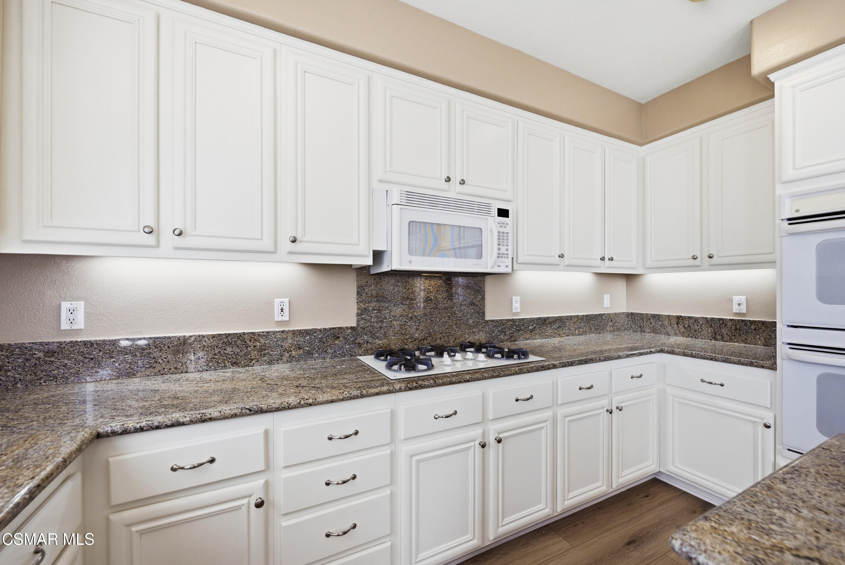 4884 Borders Street Simi Valley, CA 93063 - Photo 15 of 44 a kitchen with granite countertop white cabinets and white appliances