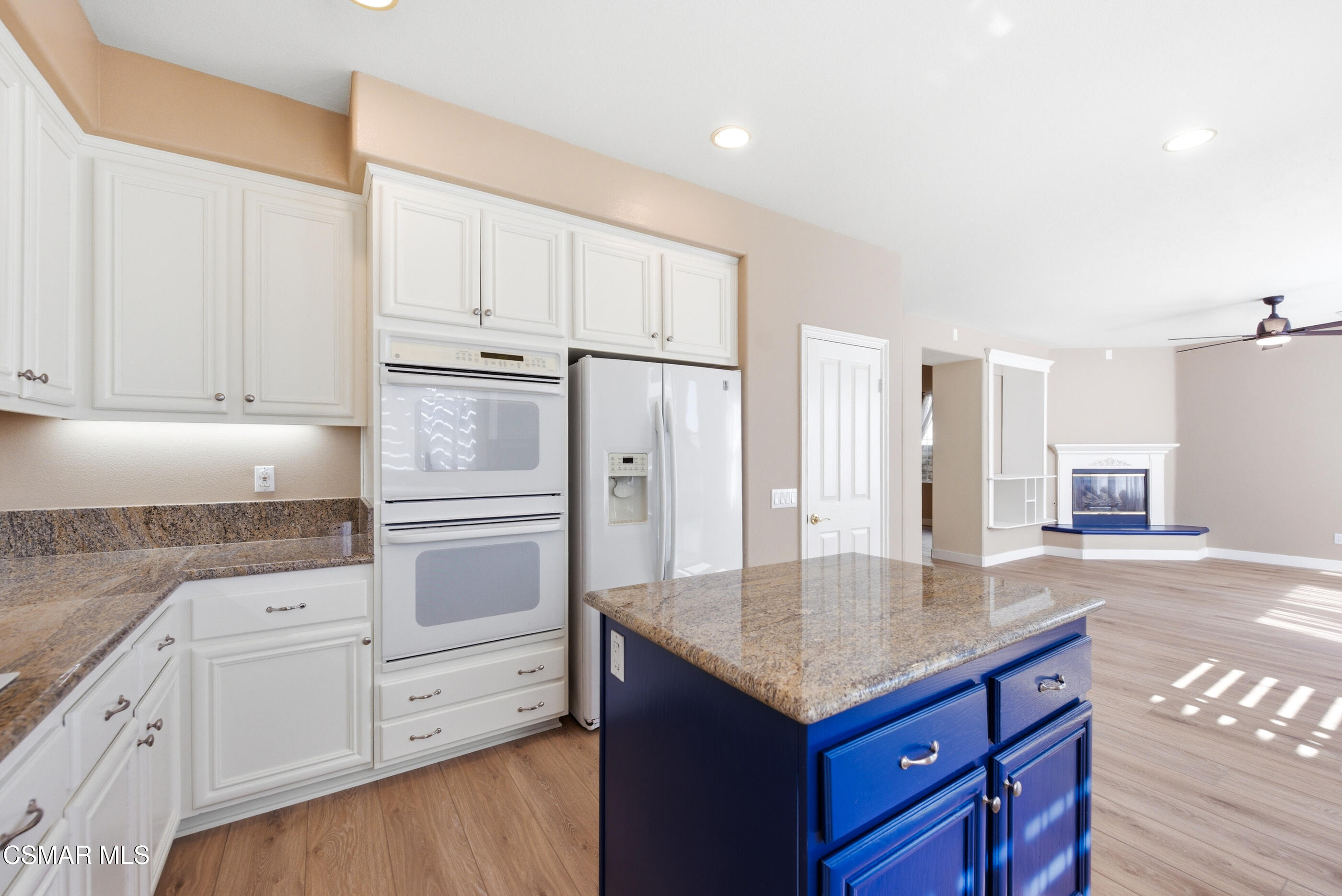 4884 Borders Street Simi Valley, CA 93063 - Photo 16 of 44 a kitchen with granite countertop white cabinets and refrigerator