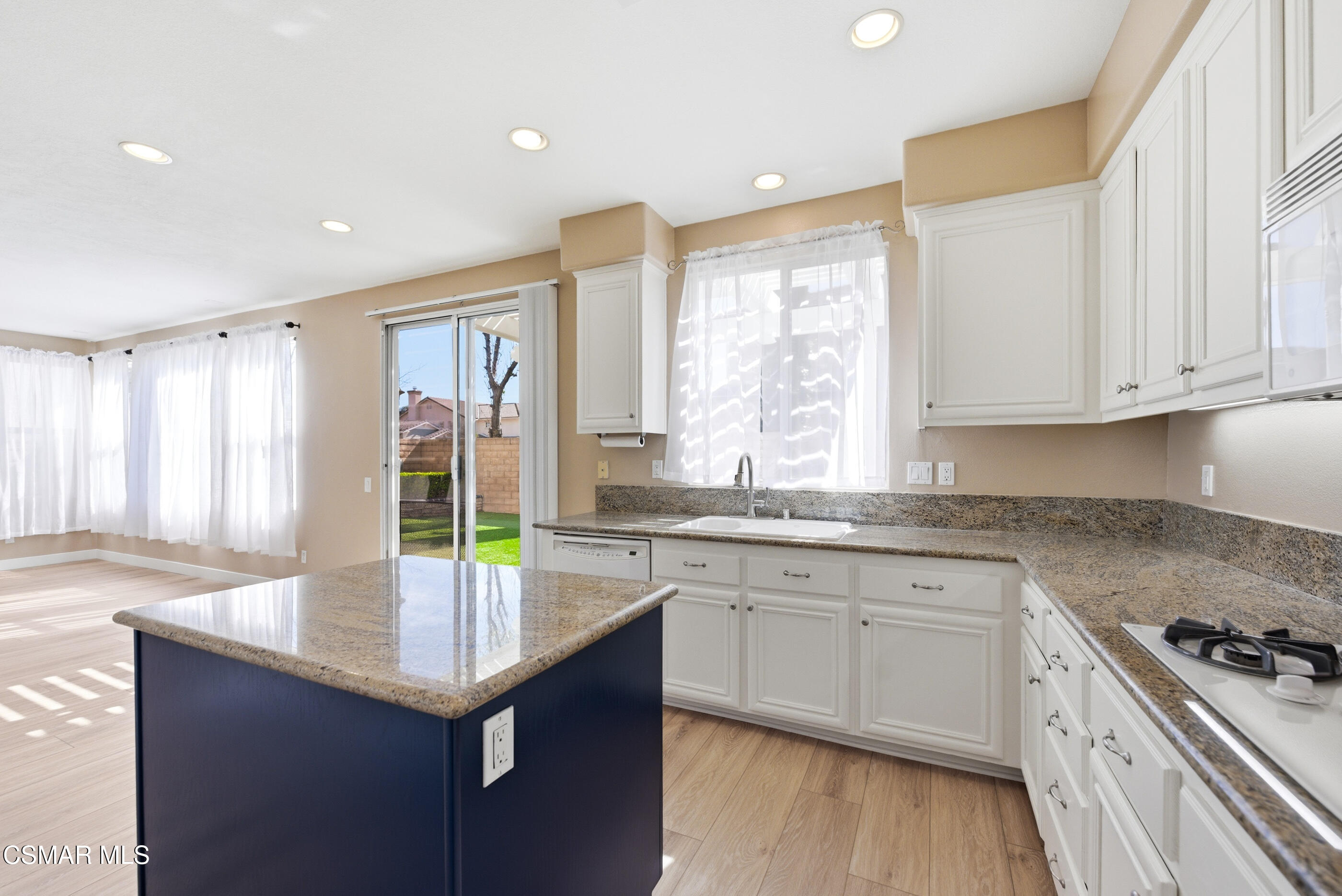4884 Borders Street Simi Valley, CA 93063 - Photo 17 of 44 a kitchen with granite countertop a sink a stove cabinets counter space and wooden floor