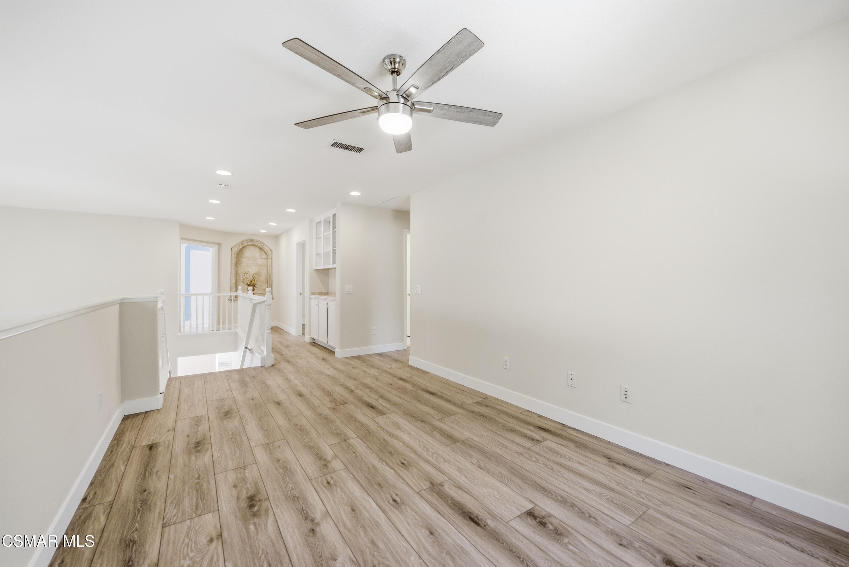 4884 Borders Street Simi Valley, CA 93063 - Photo 25 of 44 a view of an empty room with wooden floor and a ceiling fan