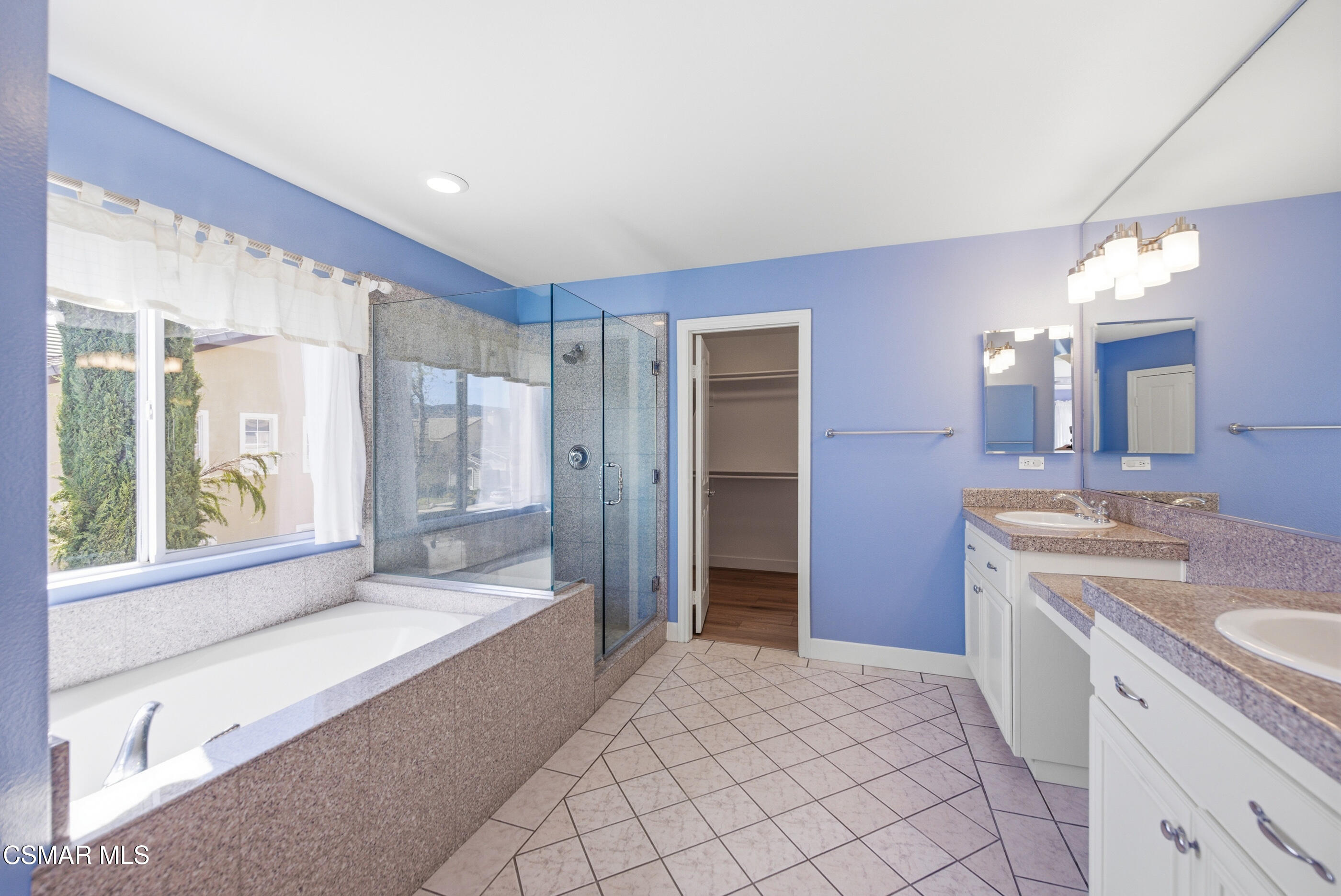 4884 Borders Street Simi Valley, CA 93063 - Photo 29 of 44 a spacious bathroom with a shower a sink and a large mirror