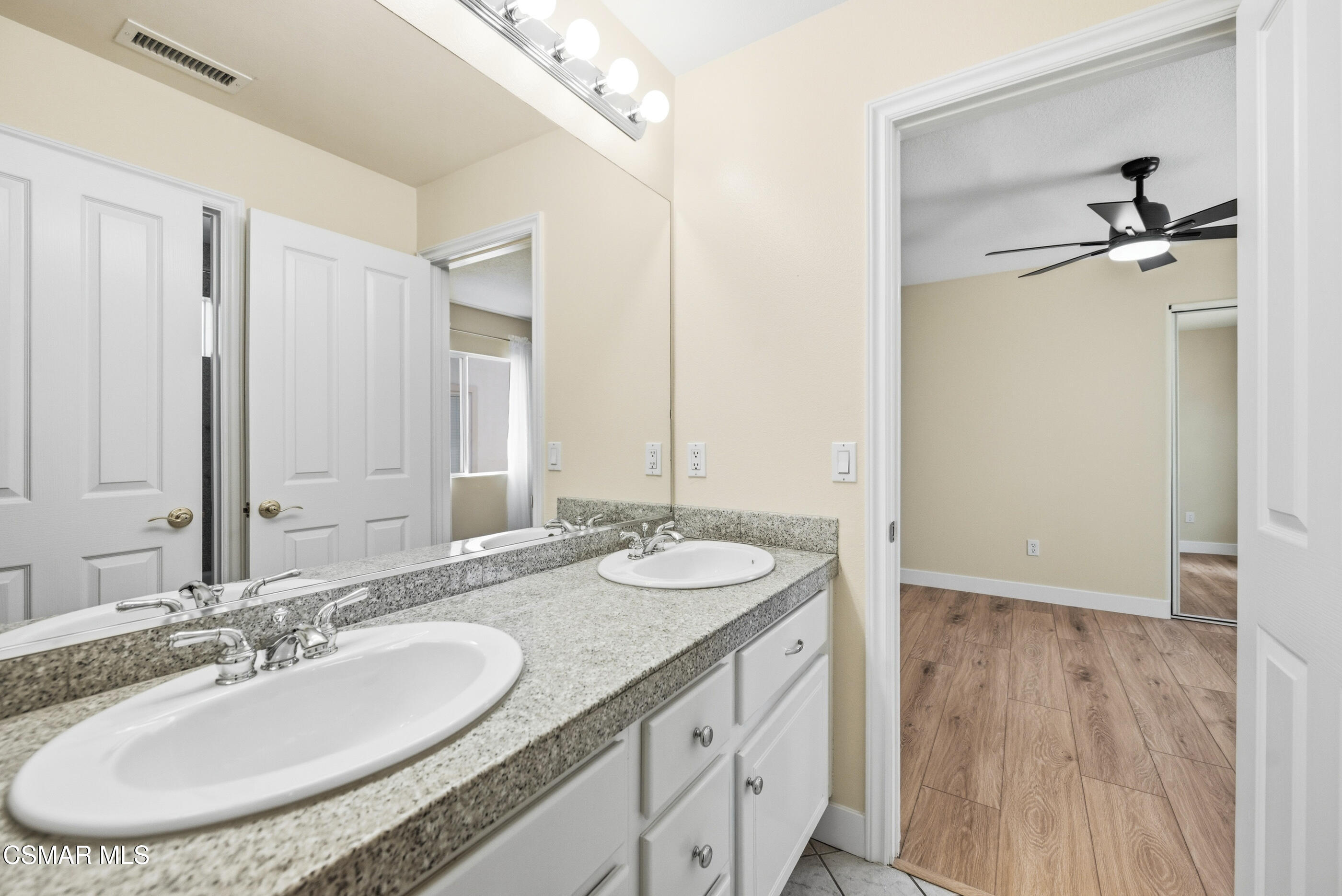 4884 Borders Street Simi Valley, CA 93063 - Photo 36 of 44 a bathroom with a granite countertop sink a mirror and a shower