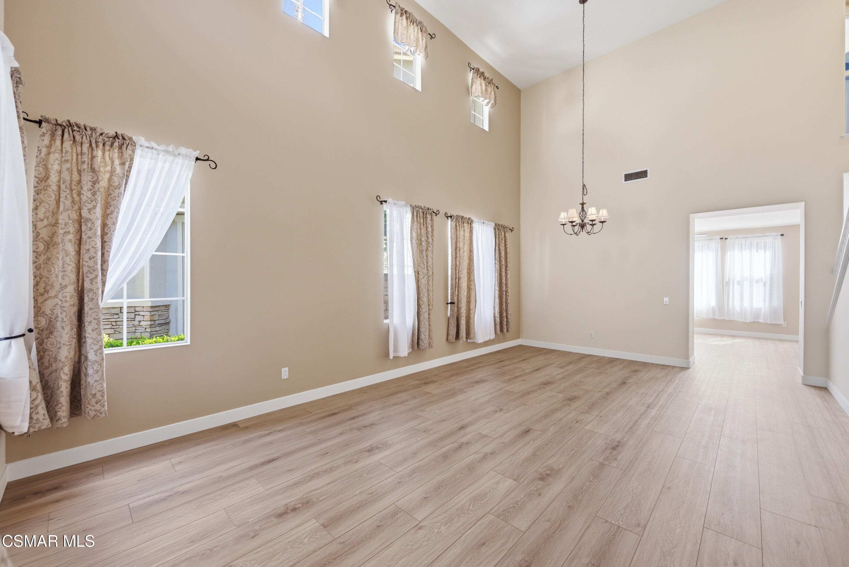 4884 Borders Street Simi Valley, CA 93063 - Photo 8 of 44 a view of an empty room with wooden floor and a window