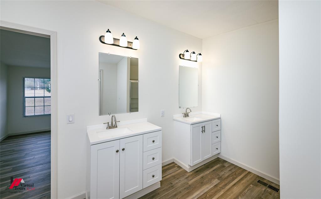 4947 Quiet Acres Road Shreveport, LA 71107 - Photo 12 of 39 Full bath featuring two vanities, dark wood-style flooring, and a shower with door