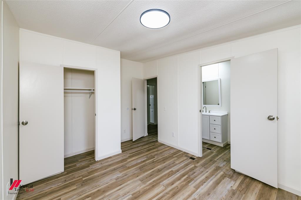 4947 Quiet Acres Road Shreveport, LA 71107 - Photo 18 of 39 Unfurnished bedroom featuring ensuite bathroom, light wood-type flooring, a closet, and a textured ceiling