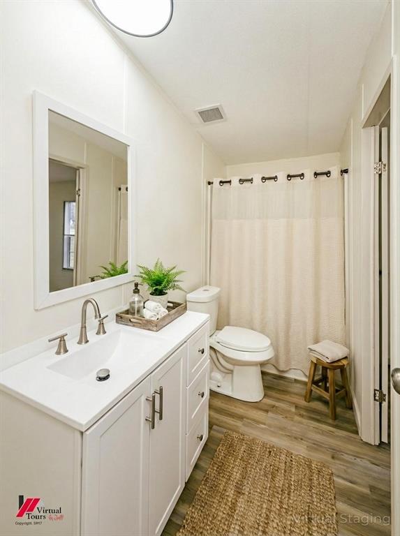 4947 Quiet Acres Road Shreveport, LA 71107 - Photo 23 of 39 Virtually Staged Bathroom featuring a shower with curtain, vanity, and dark wood-style floors
