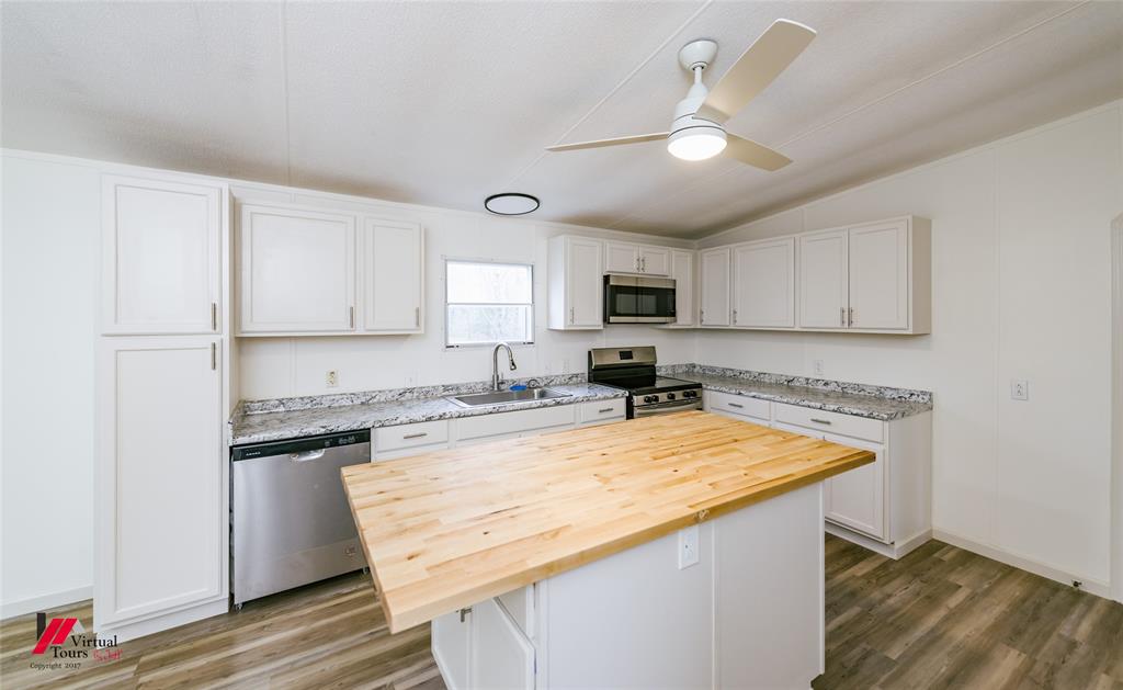 4947 Quiet Acres Road Shreveport, LA 71107 - Photo 32 of 39 Kitchen featuring butcher block countertops, appliances with stainless steel finishes, white cabinetry, light wood-style flooring, and lofted ceiling