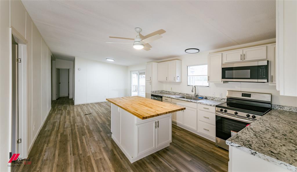 4947 Quiet Acres Road Shreveport, LA 71107 - Photo 36 of 39 Kitchen featuring stainless steel appliances, butcher block counters, a center island, a ceiling fan, and dark wood-type flooring