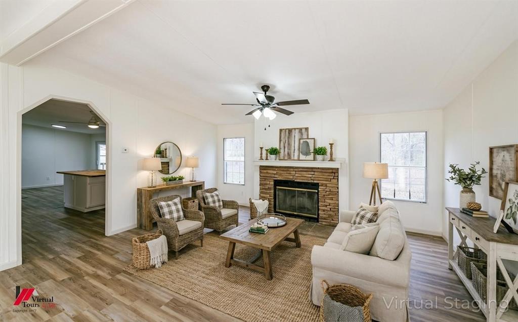 4947 Quiet Acres Road Shreveport, LA 71107 - Photo 6 of 39 Virtually Staged Living area featuring wood finished floors, a ceiling fan, arched walkways, and a stone fireplace