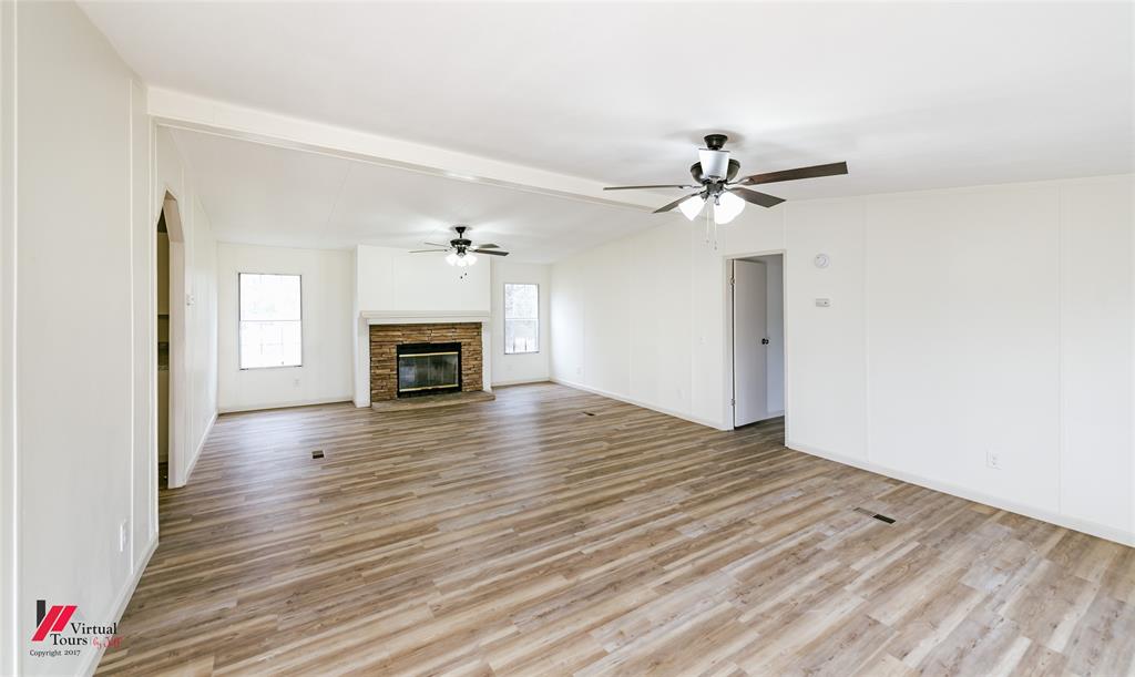 4947 Quiet Acres Road Shreveport, LA 71107 - Photo 7 of 39 Unfurnished living room with a fireplace, light wood-type flooring, and ceiling fan