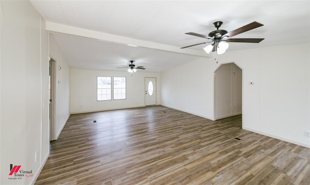 4947 Quiet Acres Road Shreveport, LA 71107 - Photo 8 of 39 Empty room featuring arched walkways, beam ceiling, light wood-style floors, and ceiling fan
