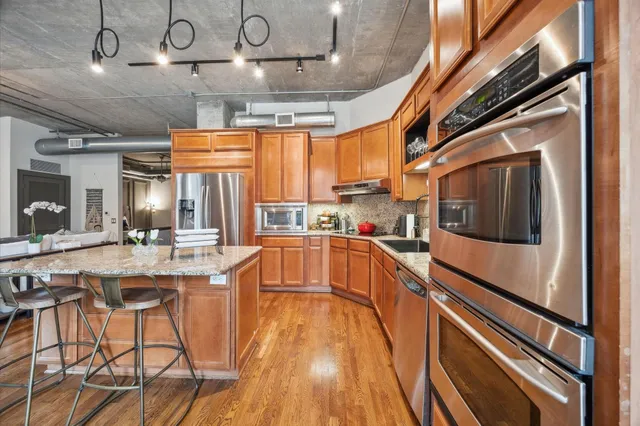 a view of a kitchen with stainless steel appliances granite countertop a sink and cabinets