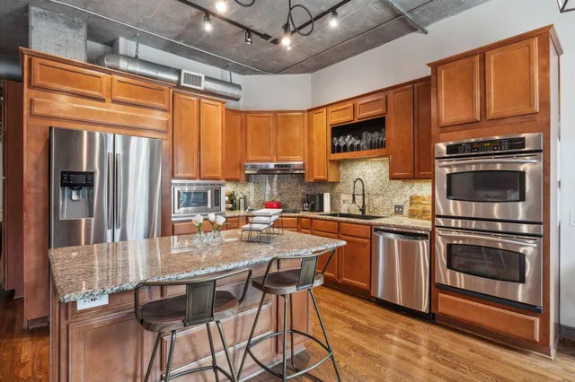 a kitchen with stainless steel appliances granite countertop a stove refrigerator and a microwave