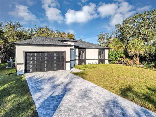 a front view of a house with a yard and garage