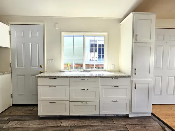 a bathroom with a granite countertop sink and a mirror
