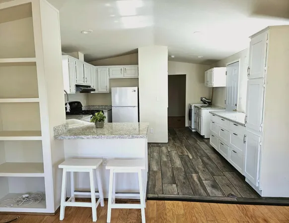 a kitchen with stainless steel appliances kitchen island granite countertop a refrigerator and microwave