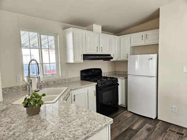a kitchen with stainless steel appliances granite countertop a refrigerator sink and stove