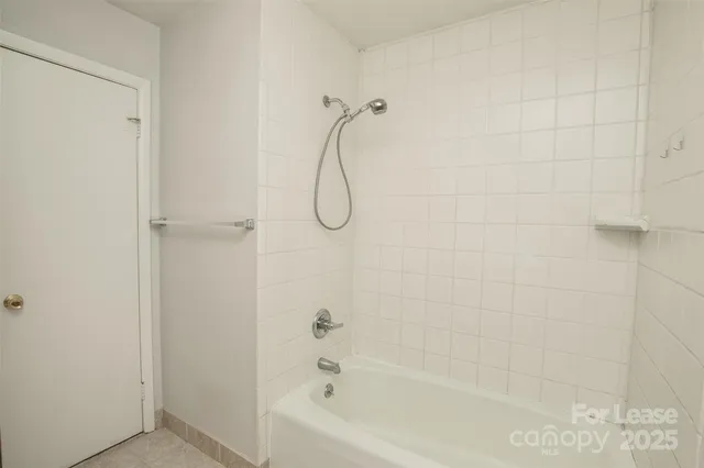 a bathroom with a bath tub with a shower