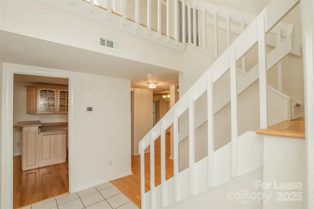 a view of staircase with lots of frames on wall and a window