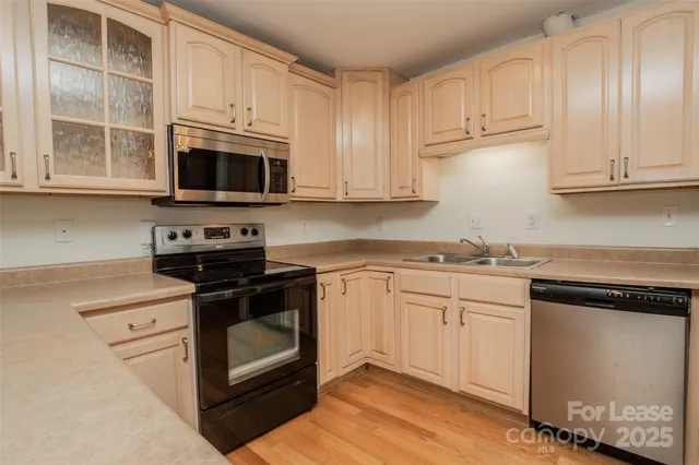 a kitchen with stainless steel appliances granite countertop a stove a microwave and a white cabinets
