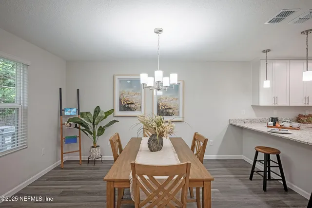 a view of a dining room with furniture wooden floor and chandelier
