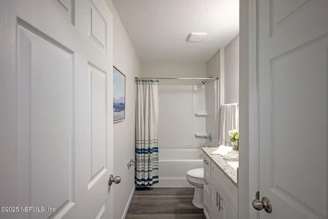a bath room with a granite countertop sink and a mirror