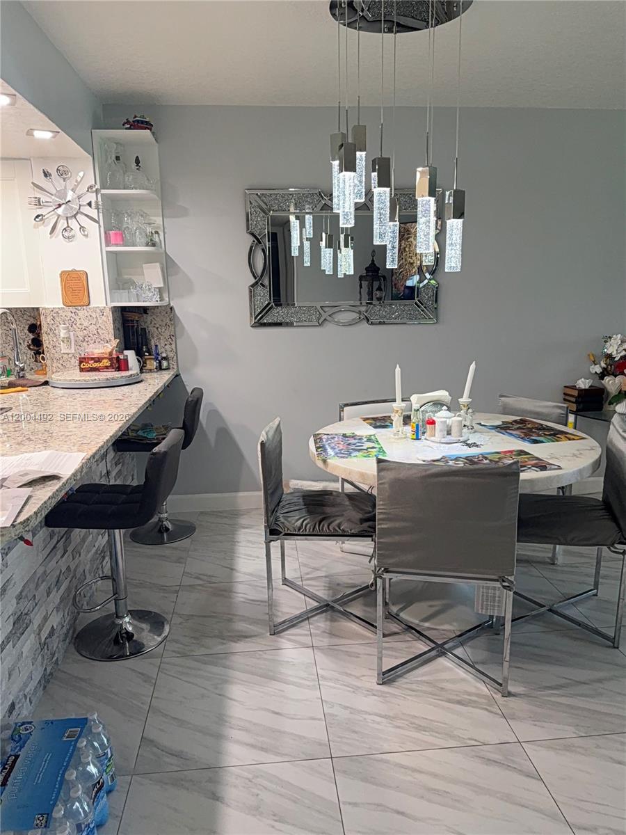 9880 Marina Boulevard, Unit 1528 Boca Raton, FL 33428 - Photo 4 of 14 a table and chairs in a kitchen