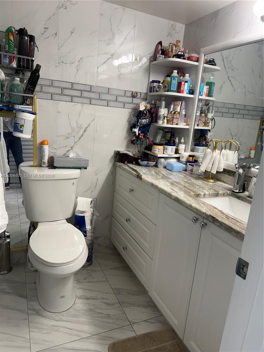 9880 Marina Boulevard, Unit 1528 Boca Raton, FL 33428 - Photo 5 of 14 a bathroom with a toilet a sink and a mirror