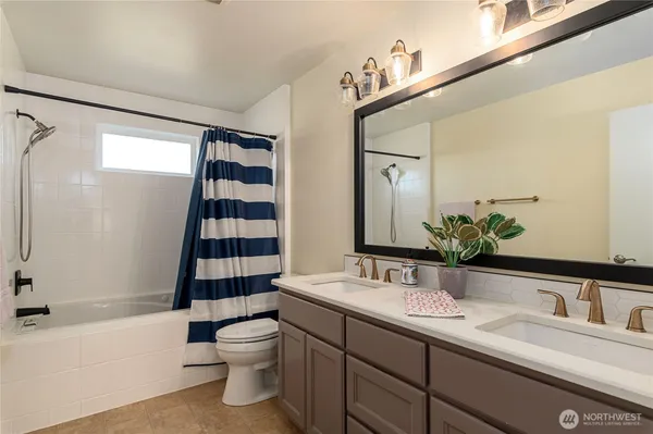 a bathroom with a double vanity sink toilet and shower