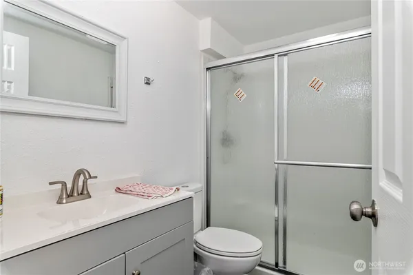a bathroom with a sink toilet a mirror and shower
