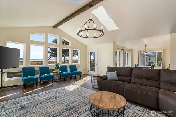 a living room with furniture a dining table and a floor to ceiling window