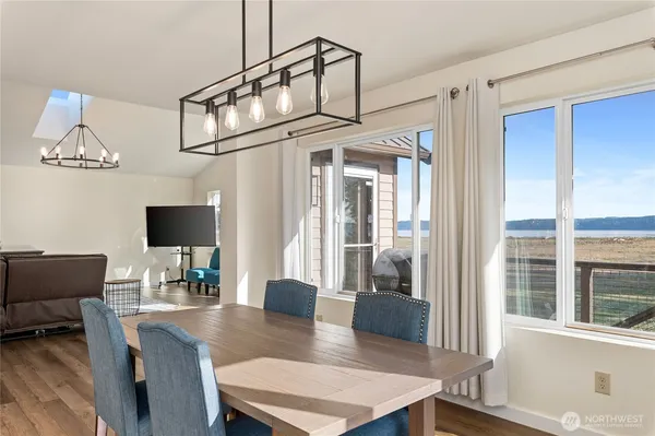 a dining room with furniture and a floor to ceiling window