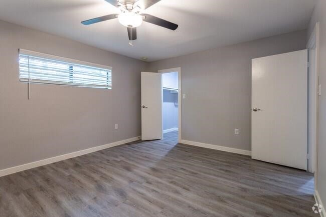 2810 Beauchamp Street, Unit 28 Houston, TX 77009 - Photo 6 of 12 an empty room with wooden floor chandelier fan and windows