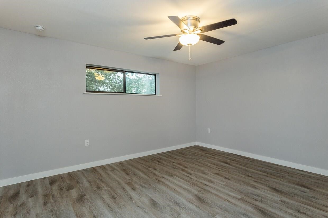 2810 Beauchamp Street, Unit 28 Houston, TX 77009 - Photo 7 of 12 an empty room with wooden floor and ceiling fan
