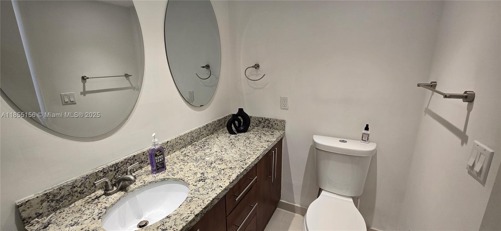 2801 Northeast 183rd Street, Unit 714W Aventura, FL 33160 - Photo 12 of 21 a bathroom with a granite countertop toilet sink and mirror