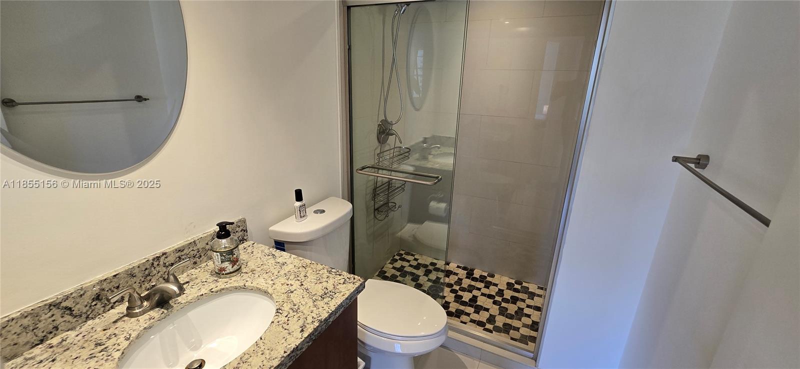 2801 Northeast 183rd Street, Unit 714W Aventura, FL 33160 - Photo 13 of 21 a bathroom with a granite countertop toilet a sink and a mirror