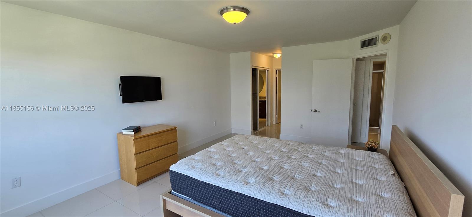 2801 Northeast 183rd Street, Unit 714W Aventura, FL 33160 - Photo 9 of 21 a bedroom with a bed and a flat screen tv